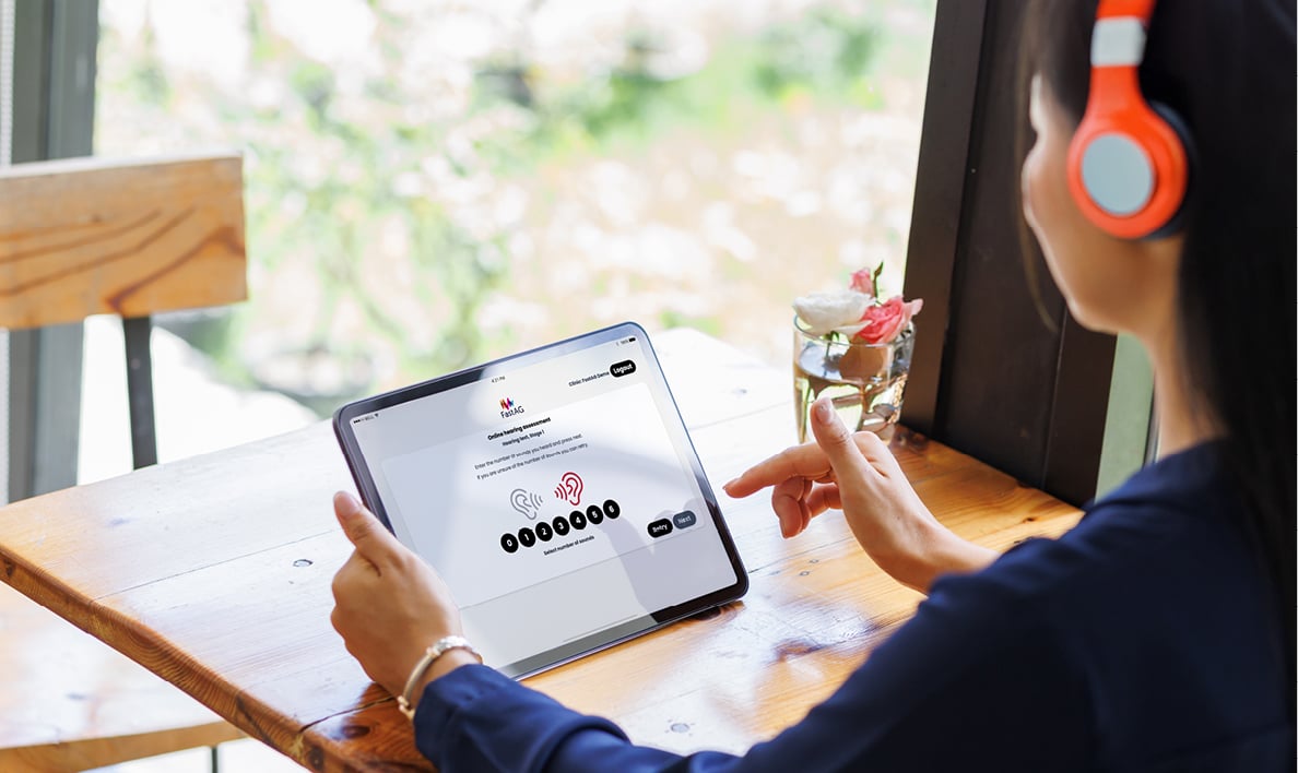 Woman taking hearing test on tablet